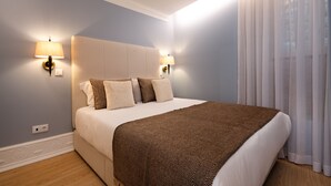 A neatly made bed with a patterned throw, two wall-mounted lamps, and sheer curtains. - RA - Flores 3 in Oporto (Porto)