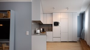 A modern kitchen with white cabinetry, a microwave, and a coffee maker. - RA - Flores 3 in Oporto (Porto)
