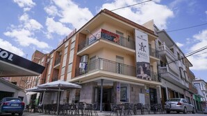 Ein mehrstöckiges Gebäude mit Restaurant im Erdgeschoss und einem sichtbaren Balkon.