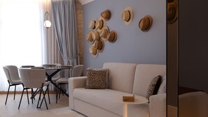 Un salon moderne comprenant un canapé, une table basse et un coin repas avec des chaises et une table.