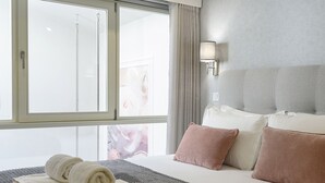 A hotel room with a large bed, a window with curtains, a wall-mounted lamp, and a view of a building outside. - RA - S o Jo o 3 in Oporto (Porto)