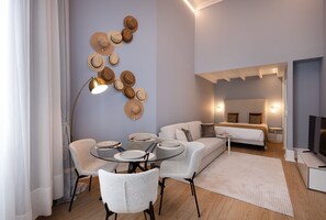 A modern living room with a round glass table, white sofa, and a wall decorated with hats. - RA - Flores 1 in Oporto (Porto)