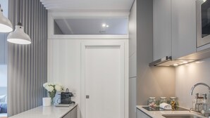 A modern kitchen with a white countertop, grey cabinets, and a built-in microwave. - RA - Baixa in Oporto (Porto)