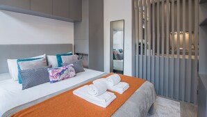 A modern hotel room with a bed, pillows, a mirror, and a sliding partition. - RA - Baixa in Oporto (Porto)
