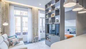 A modern living room with a sofa, TV, and dining area. - RA - Baixa in Oporto (Porto)