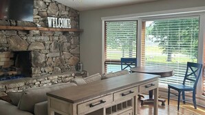Una cocina moderna con una pared de acento de piedra, un televisor integrado y un letrero que dice 'WELCOME'.
