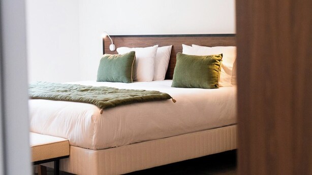 Ein Schlafzimmer mit einem Bett, Kissen und einem Nachttisch.