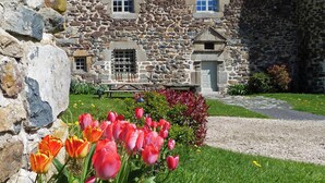 A stone building with a sloped roof and multiple windows. - Bienvenue à la Maison Forte de Chabanolles - Un lieu singulier et authentique (Retournac)