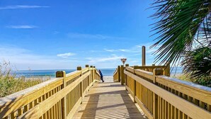 A wooden boardwalk leading to a beach with a clear view of the ocean. - Serenity Suite Oceanfront w Reclining Sofa (Myrtle Beach)