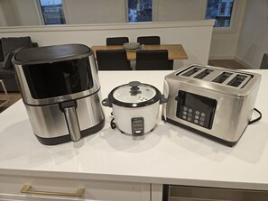 A kitchen with a coffee maker, a slow cooker, and a toaster on the counter. - Luxury 2BR Suite • Near Children’s Hospital & COP (Calgary)