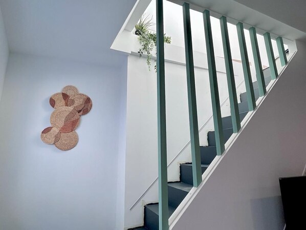 A staircase with a modern design, featuring a glass railing and a wall-mounted decorative item. - Baélia Casa Sabina (Alicante)