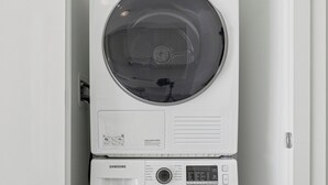 A stacked washer and dryer unit in a laundry room. - Home Richmond Hill 2bed2.5bath | Parking (Richmond Hill)