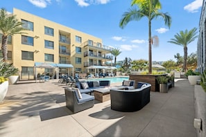 A hotel with a pool area, outdoor seating, and palm trees. - Endless Fun w/ Games and Resort-Style Amenities! (San Diego)