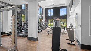 Een sportschool met loopbanden, elliptische trainers en gewichten.