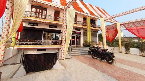 Un hotel con techo a rayas, balcones y una motocicleta estacionada afuera.