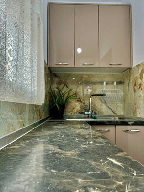 A kitchen with marble countertops, a sink, and cabinets. - Cozy 2-bedroom apartment in peaceful Tiranë with AC (Tiranë)