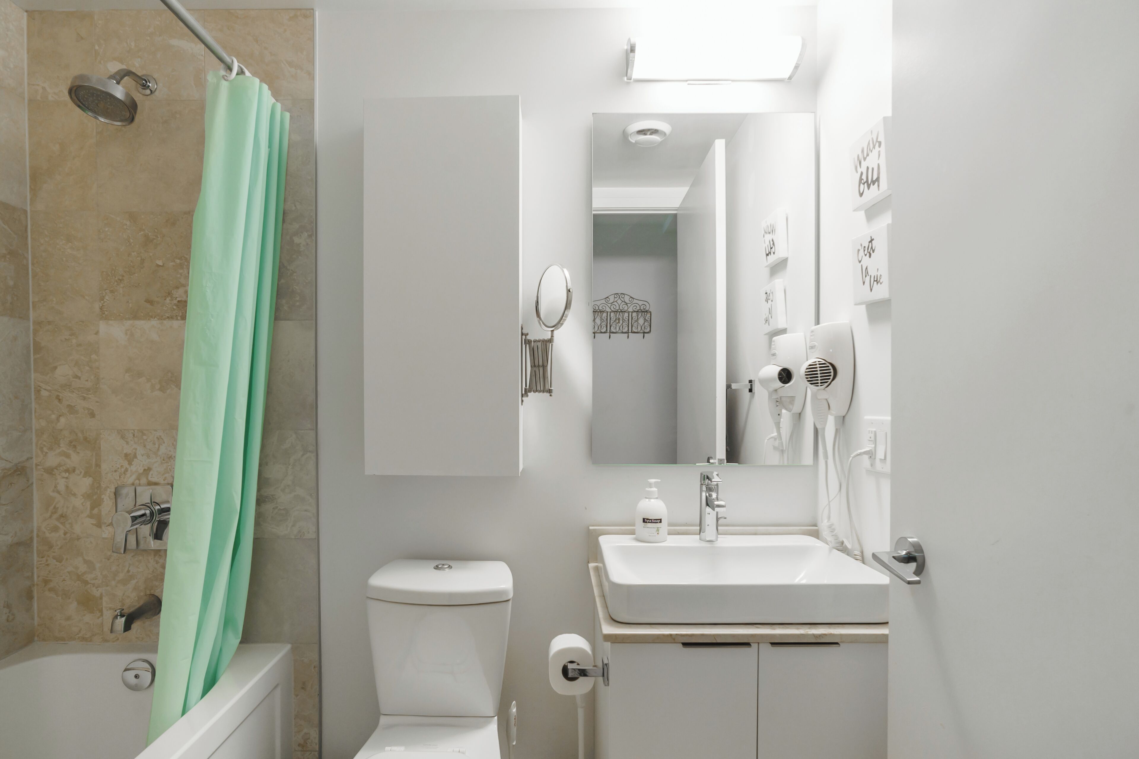 Baño con ducha, inodoro, lavabo y espejo.