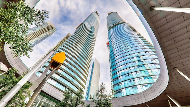 A modern building with a curved glass facade and multiple floors.