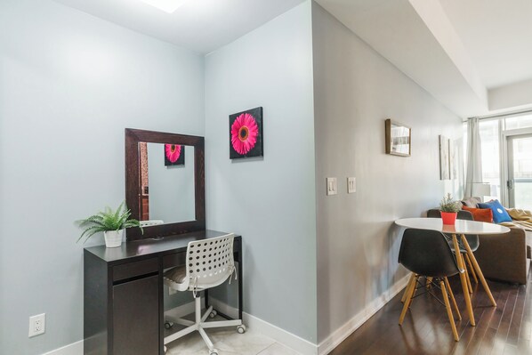 A modern living room with a dining area, a sofa, a coffee table, and a large window providing natural light.