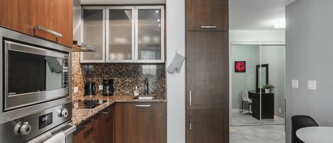 A modern kitchen with stainless steel appliances, wooden cabinets, and a granite countertop.