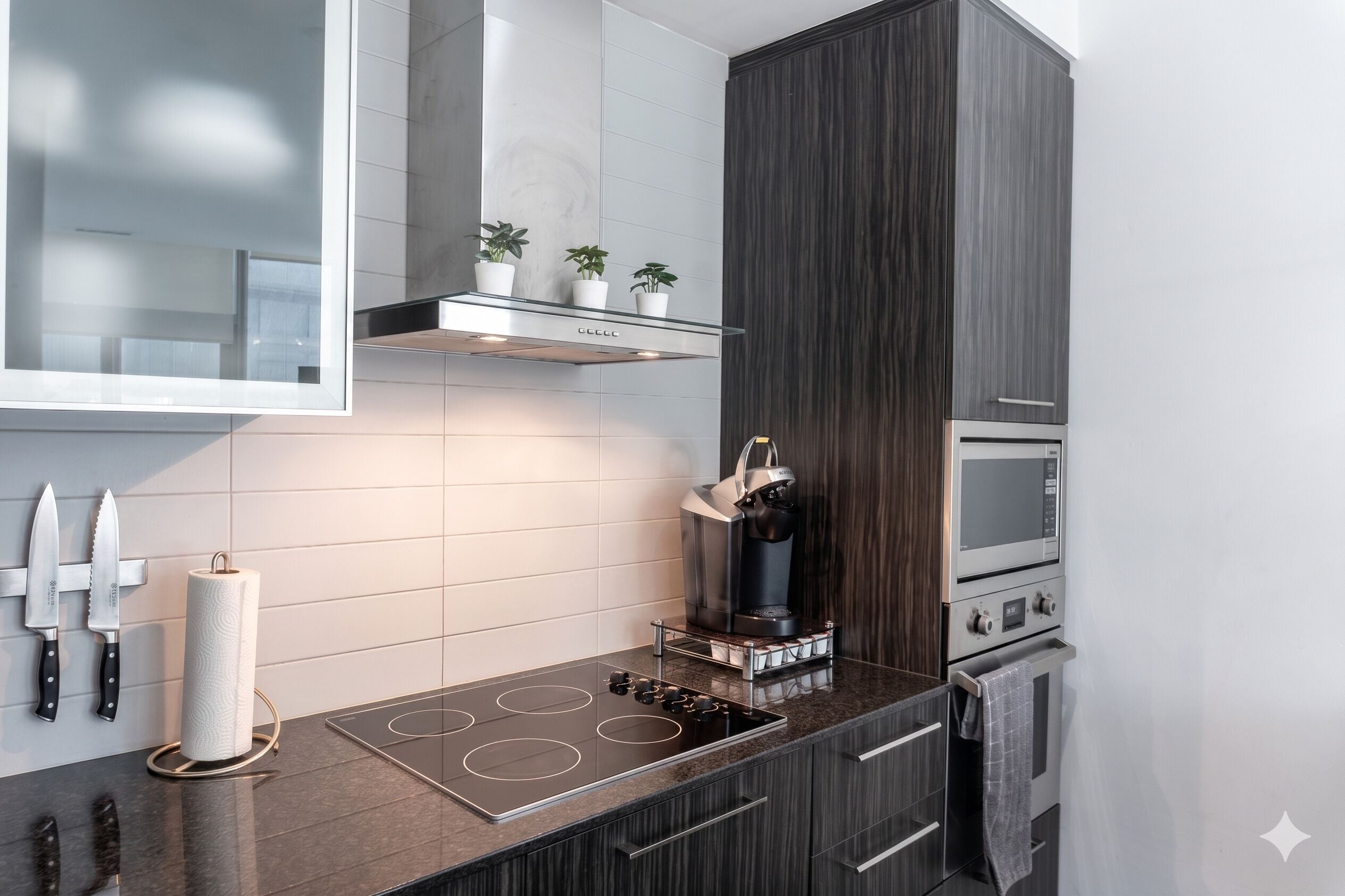 Une cuisine moderne équipée d’une cuisinière intégrée, d’une machine à café et d’un four à micro-ondes.