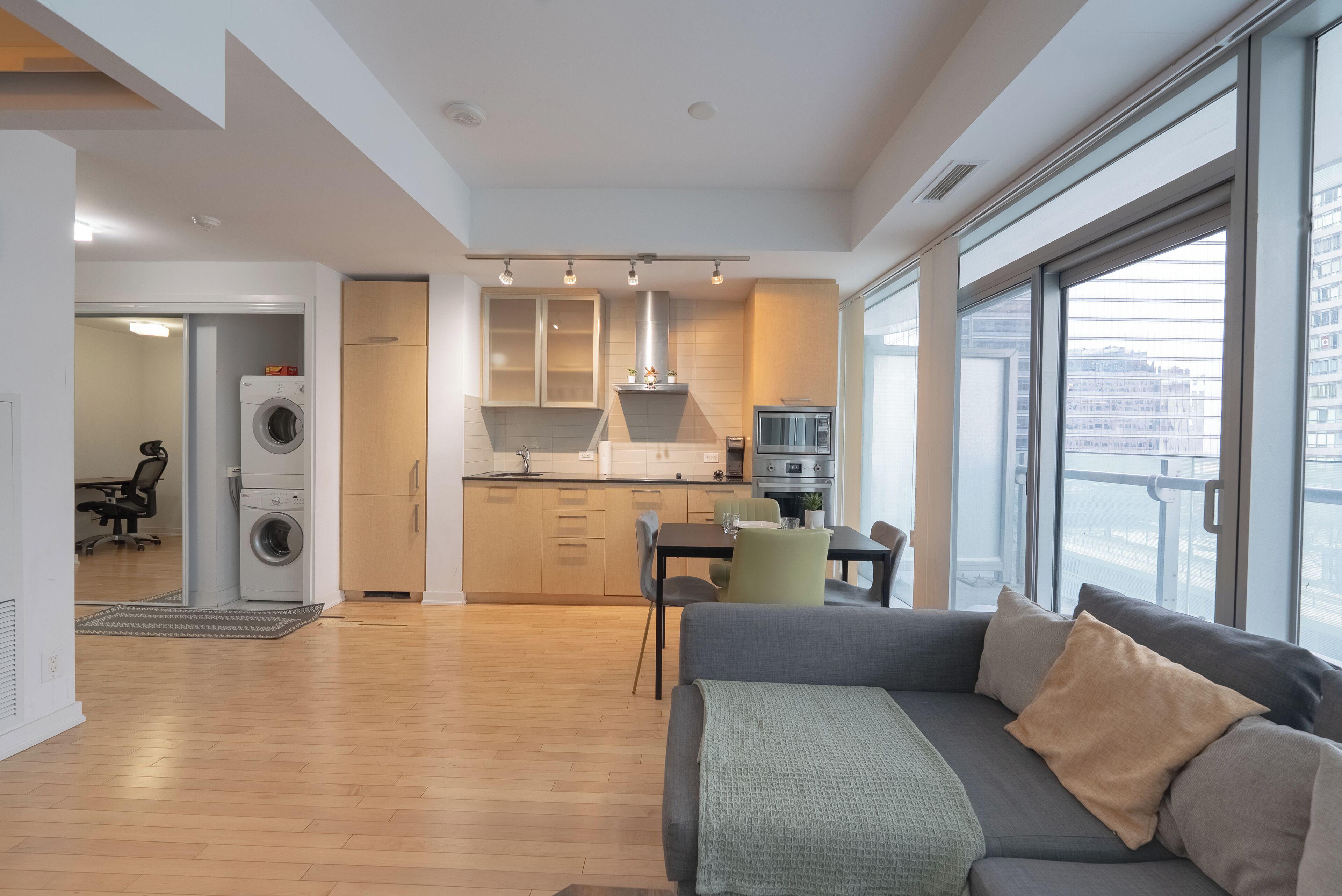 A modern apartment with a kitchen, dining area, and a living room with a sofa.