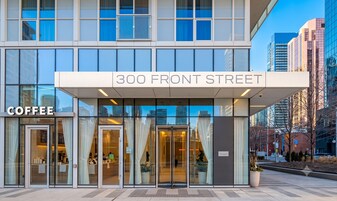 Een modern gebouw met een bord waarop '300 Front Street' staat en een ingang met 'Coffee' erbij.