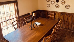 Ein Esszimmer mit einem Holztisch, Stühlen und einem an der Wand befestigten Hirschkopf.