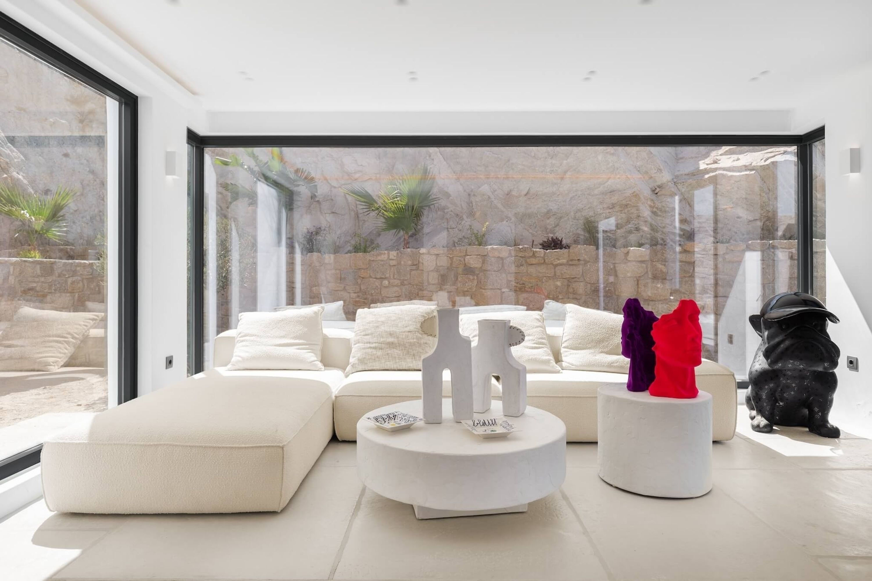 A modern living room with a white sofa, a round coffee table, and decorative items.