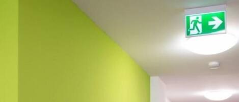 Un couloir avec un mur vert et un panneau indiquant l’emplacement de la réception.