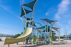 A playground with slides and climbing structures, set on a sandy area with clear skies. - MH134B Stunning 5 bdrm 3.5 bath w/ elevator (Myrtle Beach)