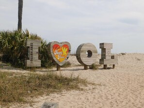 Holzbuchstaben zeigen 'OCEAN LAKES', mit einem herzförmigen Schild mit der Aufschrift 'Willkommen im Happy Place!'