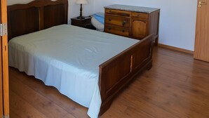 A bedroom with a wooden bed, a dresser, a nightstand, and a lamp. - Luxury House in Gated Community in Metropolitan Area (Mogi das Cruzes)