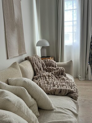 Una habitació acollidora amb un llit gran, una làmpada i una finestra amb cortines.