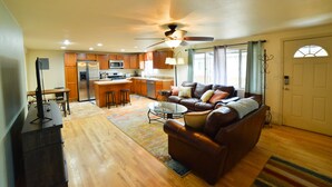 A spacious living room with a leather sofa, a coffee table, and a ceiling fan. - 1014b Swope (Colorado Springs)