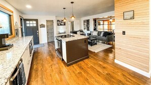 A modern kitchen with granite countertops, a central island, and pendant lighting. - 1625 E Cache La Poudre (Colorado Springs)
