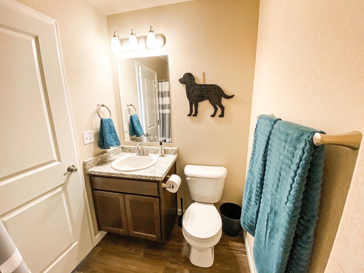 Une salle de bain équipée d’un lavabo, de toilettes et d’un porte-serviettes.