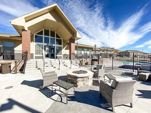 A building with a large entrance, outdoor seating area with wicker furniture, and a fire pit. - 2102 Birmingham (Colorado Springs)
