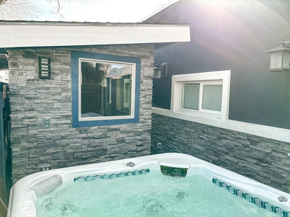 A hot tub with stone walls and a window.