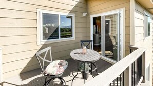 A balcony with a table and chairs, a window, and a sliding glass door. - 1040 Pond Side (Colorado Springs)
