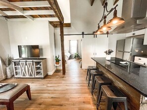 Eine moderne Küche mit Holzböden, einer Bar und einem Essbereich.