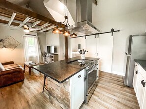 A modern kitchen with a central island, stainless steel appliances, and a farmhouse ceiling. - 1208b W Colorado (Colorado Springs)