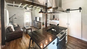 Ein kompakter Wohnraum mit einer Küche, einem Essbereich und einer Schlafecke.