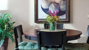 A dining area with a round table, chairs, a vase with flowers, a hanging light fixture, and a framed artwork on the wall. - RC 2050 309 (Coeur d'Alene)