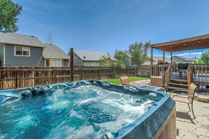 A backyard with a hot tub, wooden deck, and a covered patio area. - Hot Tub Retreat Near Fort Carson (Colorado Springs)