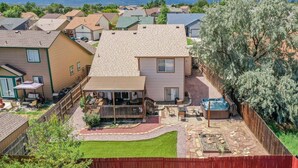 A residential area with houses, a backyard with a hot tub, and mountains in the background. - Hot Tub Retreat Near Fort Carson (Colorado Springs)