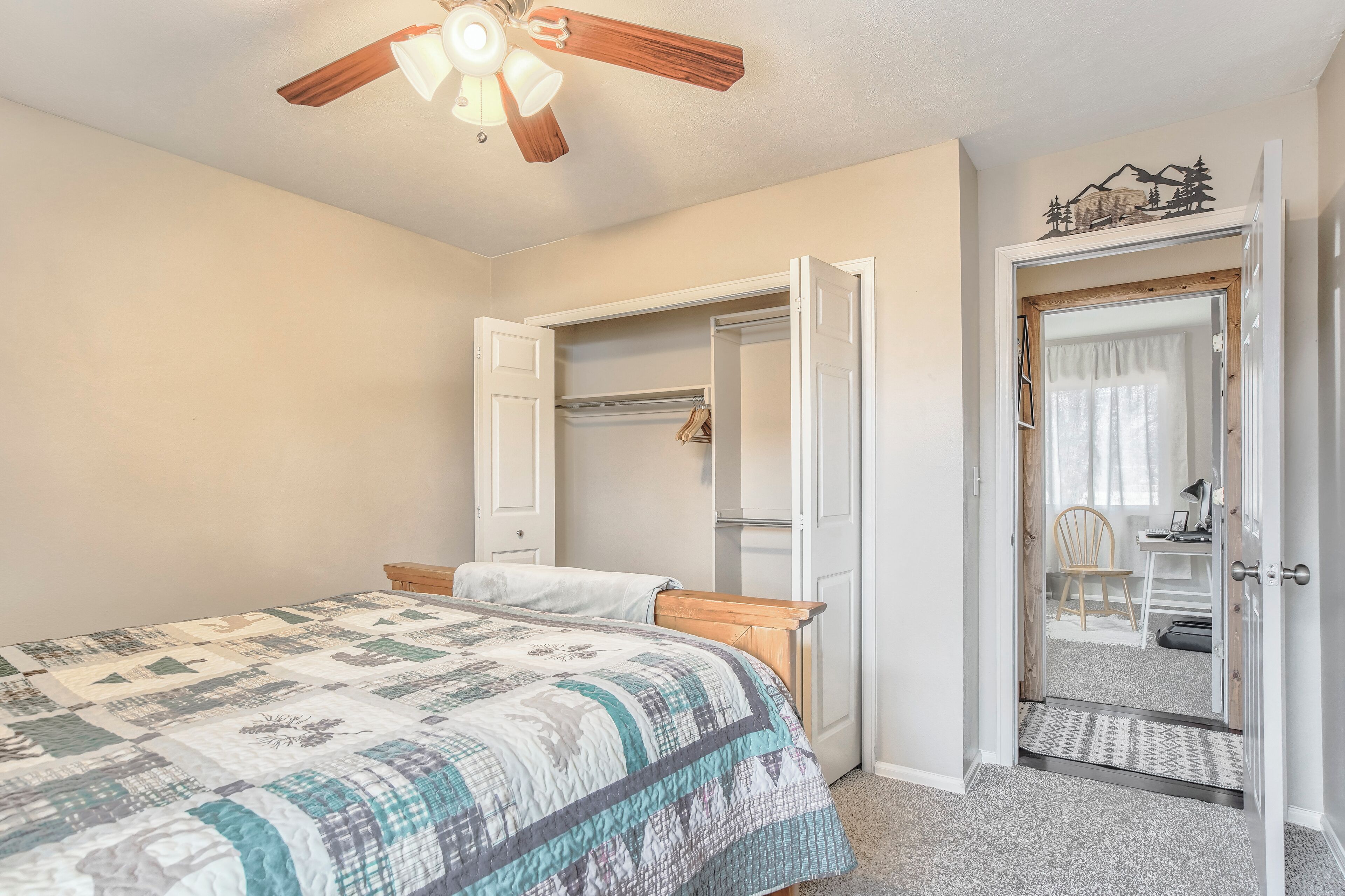 Ein Schlafzimmer mit Bett, Schrank und einer Tür zu einem anderen Raum.