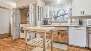 A compact kitchen with a washing machine, a coffee maker, and a dishwasher. - One Level Home Near Downtown Hot Tub (Colorado Springs)