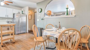 A kitchen with a refrigerator, wooden chairs, a dining table, and a ceiling fan. - One Level Home Near Downtown Hot Tub (Colorado Springs)
