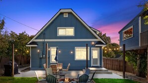 A two-story house with a covered patio area featuring outdoor seating and a fire pit. - Mt 00507 (Coeur d'Alene)